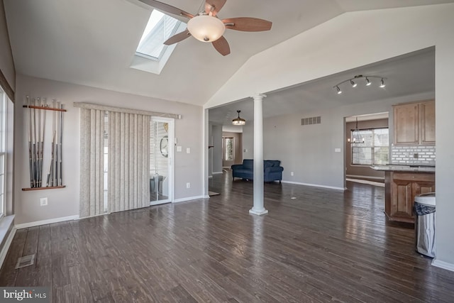 unfurnished living room with dark wood-style floors, visible vents, and ornate columns