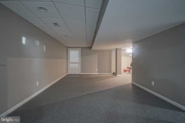 finished below grade area with a paneled ceiling, visible vents, and baseboards