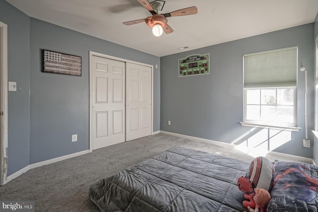 bedroom with a closet, visible vents, a ceiling fan, carpet flooring, and baseboards