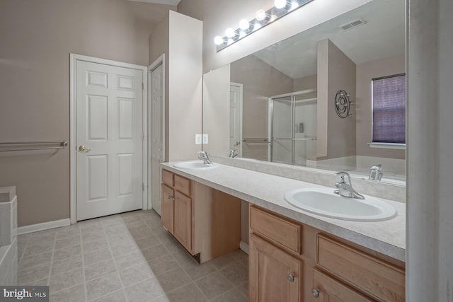 bathroom featuring double vanity, visible vents, a sink, and a shower with shower door