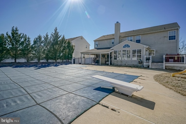 back of property with a chimney, a patio area, and a deck