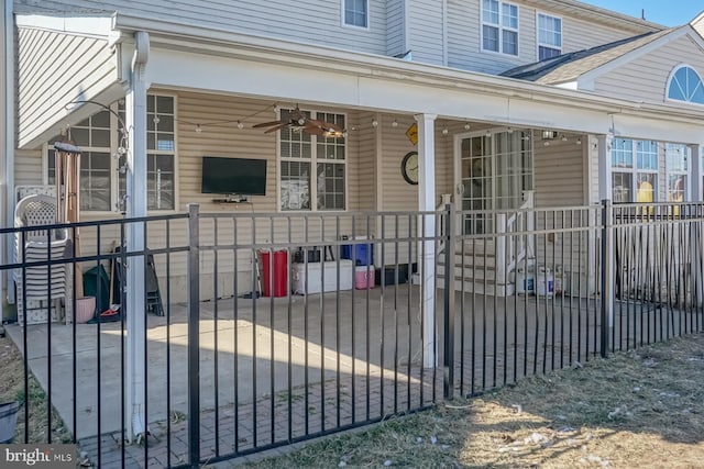 doorway to property with ceiling fan and fence