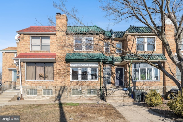 townhome / multi-family property featuring brick siding and a chimney