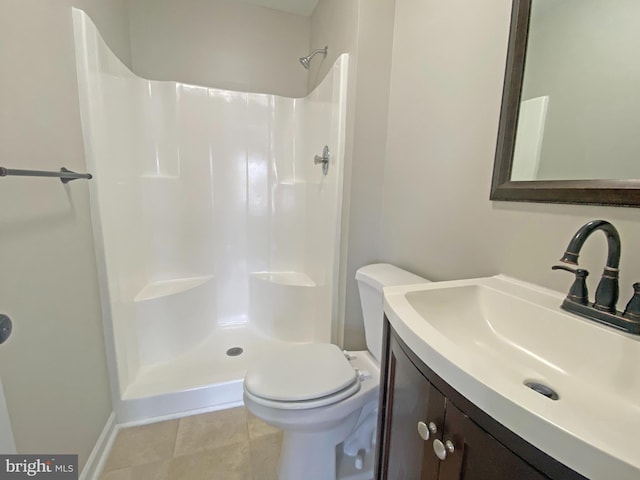 bathroom with tile patterned flooring, vanity, toilet, and walk in shower