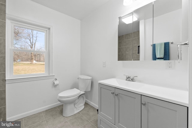 bathroom featuring tile patterned flooring, vanity, a healthy amount of sunlight, and toilet