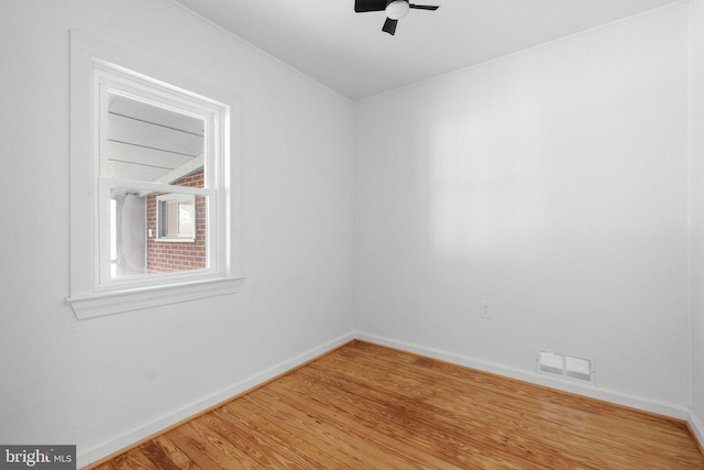 spare room featuring ornamental molding, ceiling fan, and light wood-type flooring