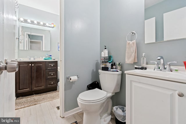 bathroom featuring vanity, hardwood / wood-style floors, and toilet