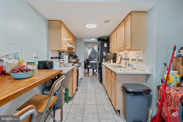 kitchen featuring sink, light tile patterned floors, range with electric cooktop, tasteful backsplash, and light brown cabinetry