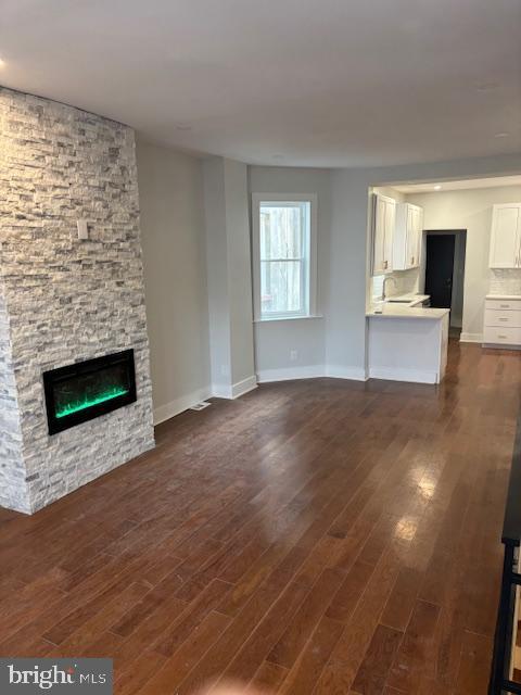 unfurnished living room featuring dark hardwood / wood-style flooring and a fireplace