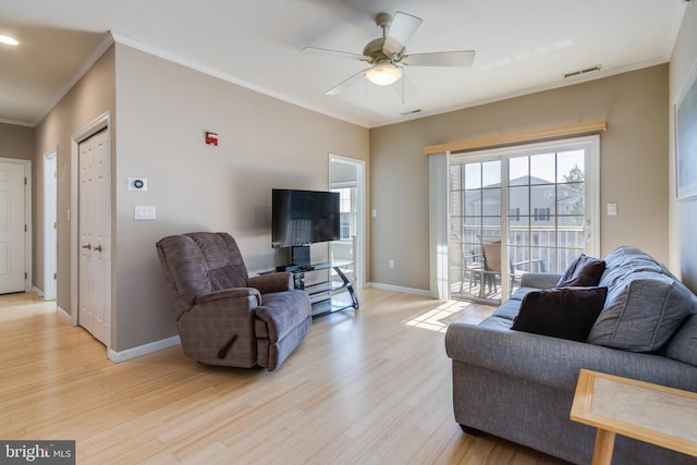 living room featuring ornamental molding, ceiling fan, and light wood-type flooring