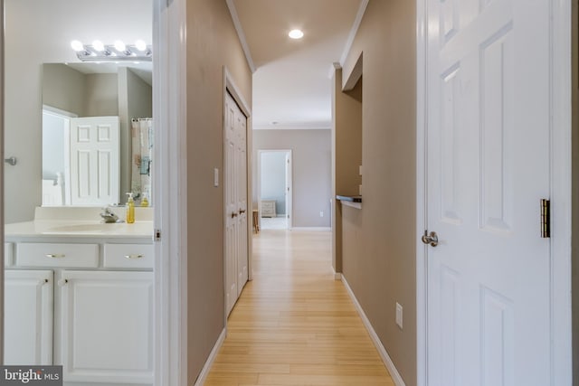 hallway featuring sink and light wood-type flooring