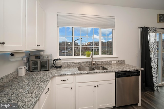 kitchen featuring dark hardwood / wood-style floors, sink, white cabinets, stainless steel dishwasher, and light stone countertops