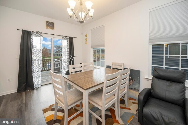 dining space with dark hardwood / wood-style floors and an inviting chandelier