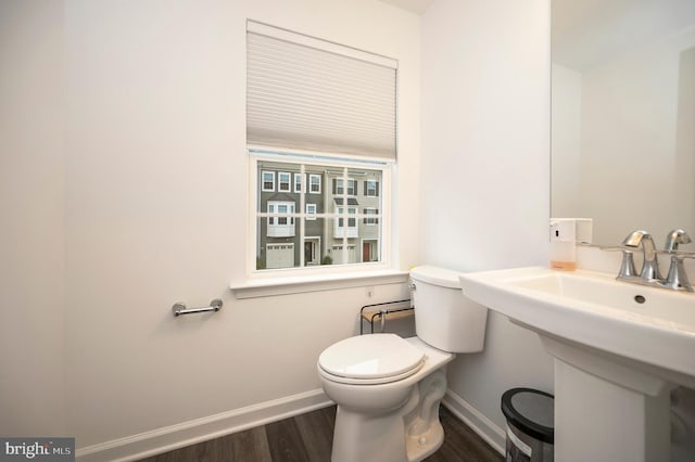 bathroom with hardwood / wood-style flooring and toilet