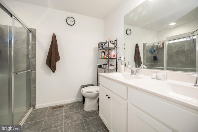 bathroom featuring vanity, tile patterned floors, a shower with door, and toilet