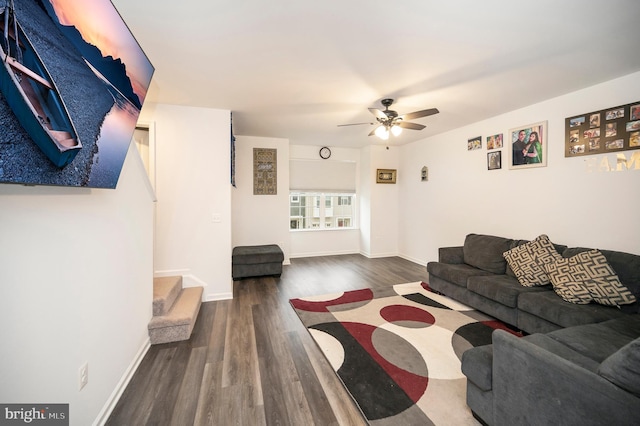 living room featuring dark wood-type flooring and ceiling fan