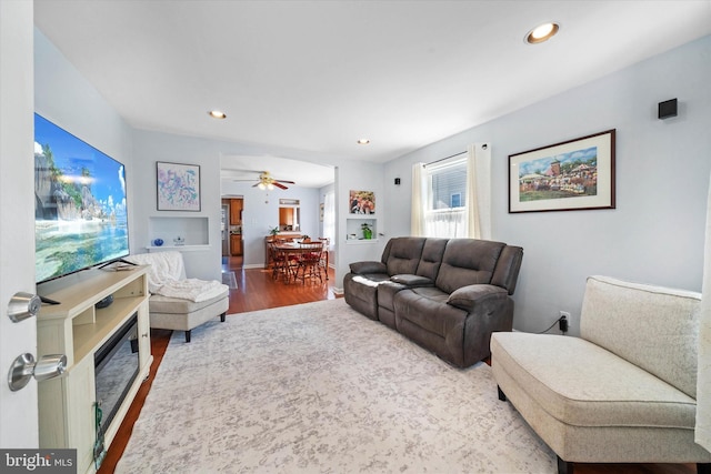 living area with baseboards, wood finished floors, and recessed lighting