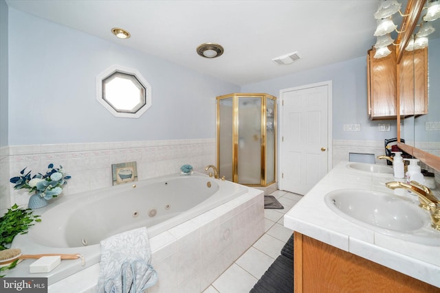 bathroom featuring a jetted tub, a sink, visible vents, and tile patterned floors