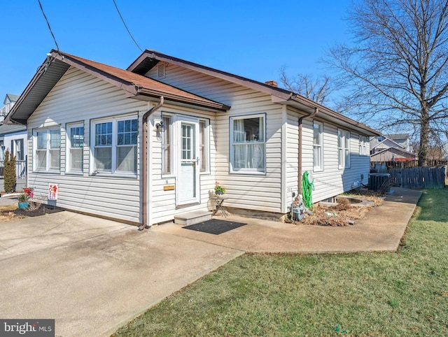 rear view of house with central AC unit and fence