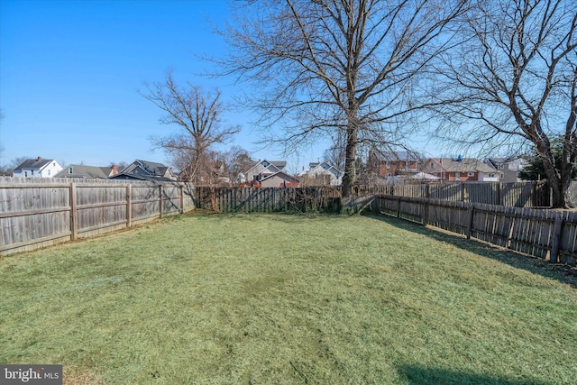 view of yard featuring a fenced backyard and a residential view