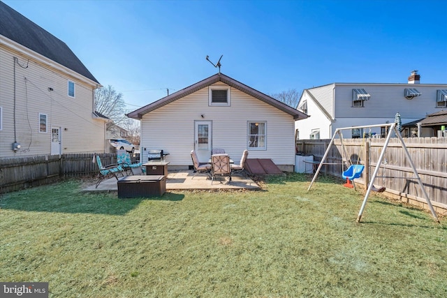 rear view of house with a patio area, a lawn, and a fenced backyard