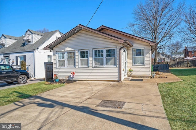 bungalow-style home featuring fence and a front lawn