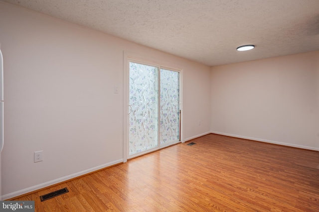 empty room featuring light hardwood / wood-style flooring and a textured ceiling