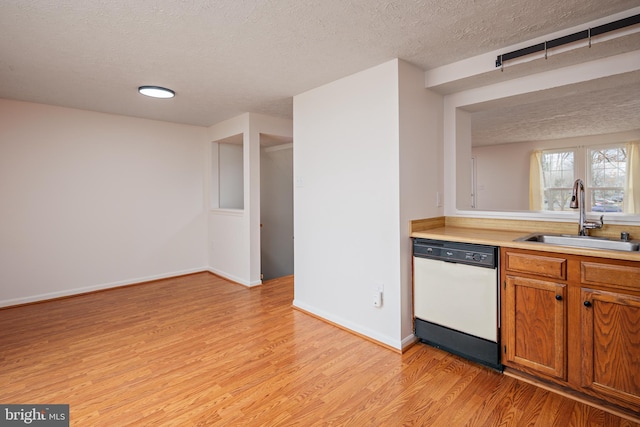 kitchen featuring sink, a textured ceiling, dishwasher, and light wood-type flooring