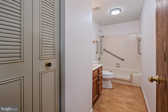 bathroom with vanity, toilet, hardwood / wood-style floors, and a textured ceiling