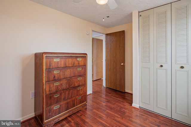 bedroom with a closet, dark hardwood / wood-style floors, and a textured ceiling