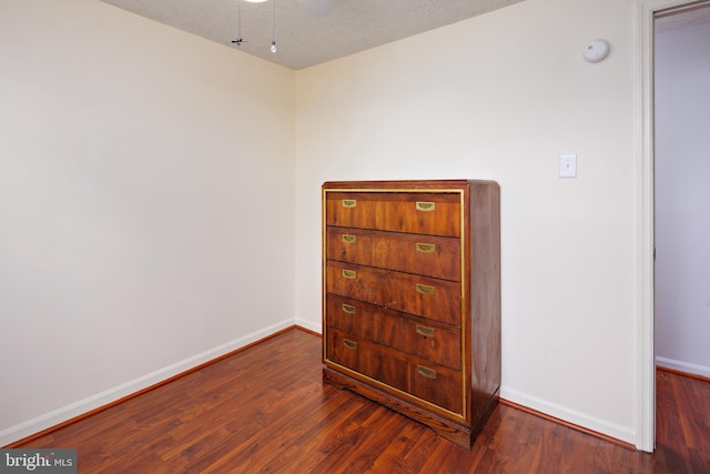 spare room with dark wood-type flooring and a textured ceiling