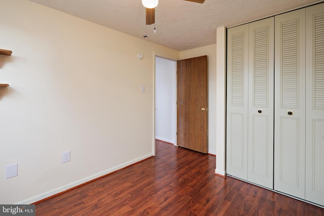 unfurnished bedroom featuring ceiling fan, dark hardwood / wood-style floors, a closet, and a textured ceiling