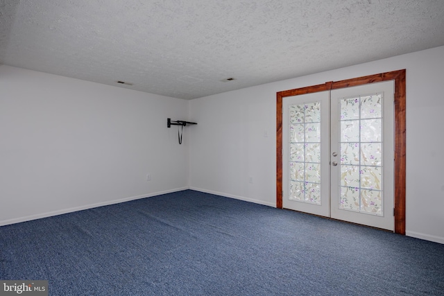 carpeted empty room featuring french doors and a textured ceiling