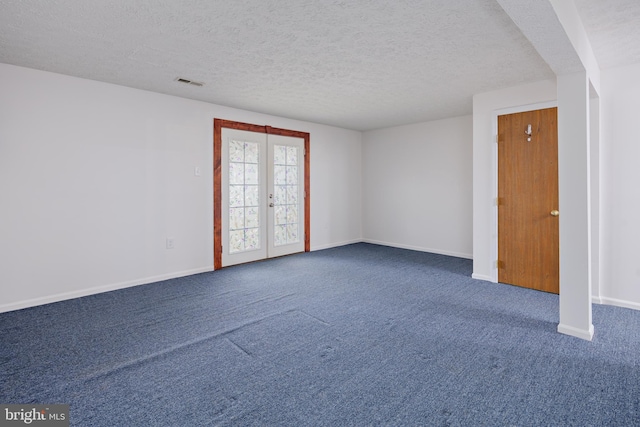 empty room featuring carpet floors, a textured ceiling, and french doors