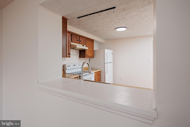 kitchen featuring white appliances and a textured ceiling