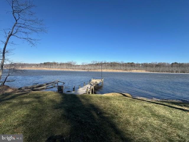 dock area with a yard and a water view