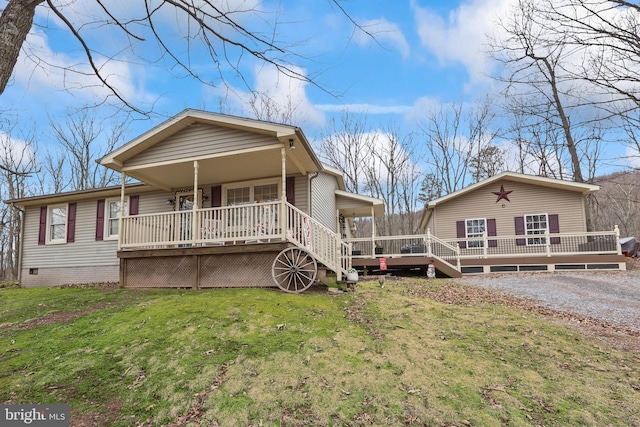 back of property featuring covered porch and a lawn