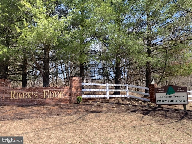 community / neighborhood sign featuring fence