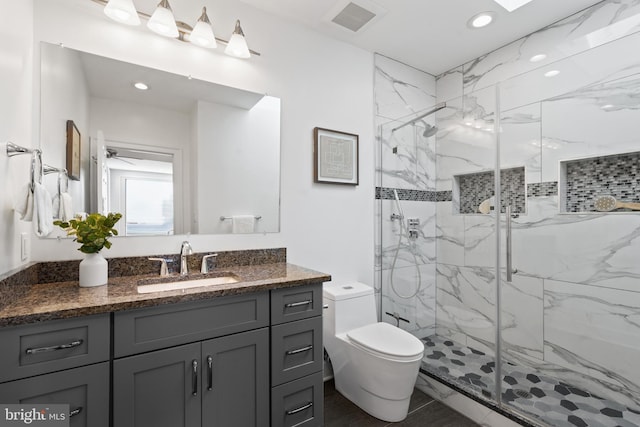 bathroom featuring vanity, toilet, and walk in shower