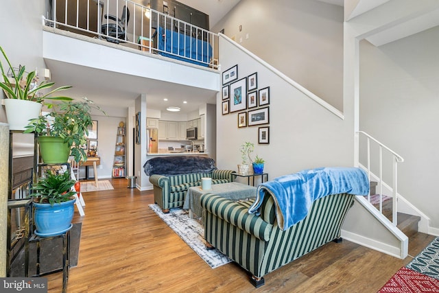 living room with a towering ceiling and hardwood / wood-style floors