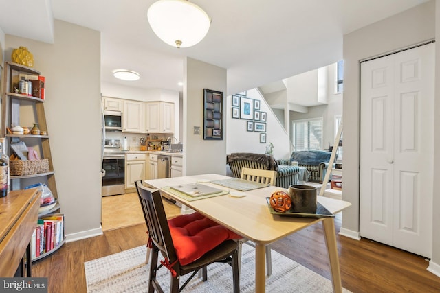 dining area with sink and wood-type flooring