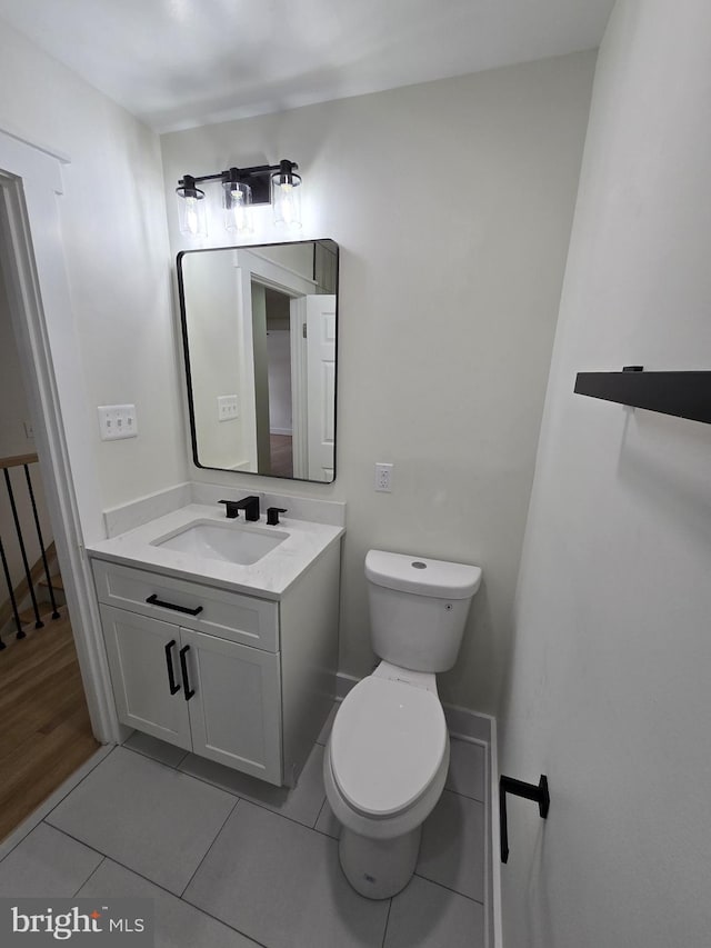 bathroom featuring tile patterned flooring, vanity, and toilet