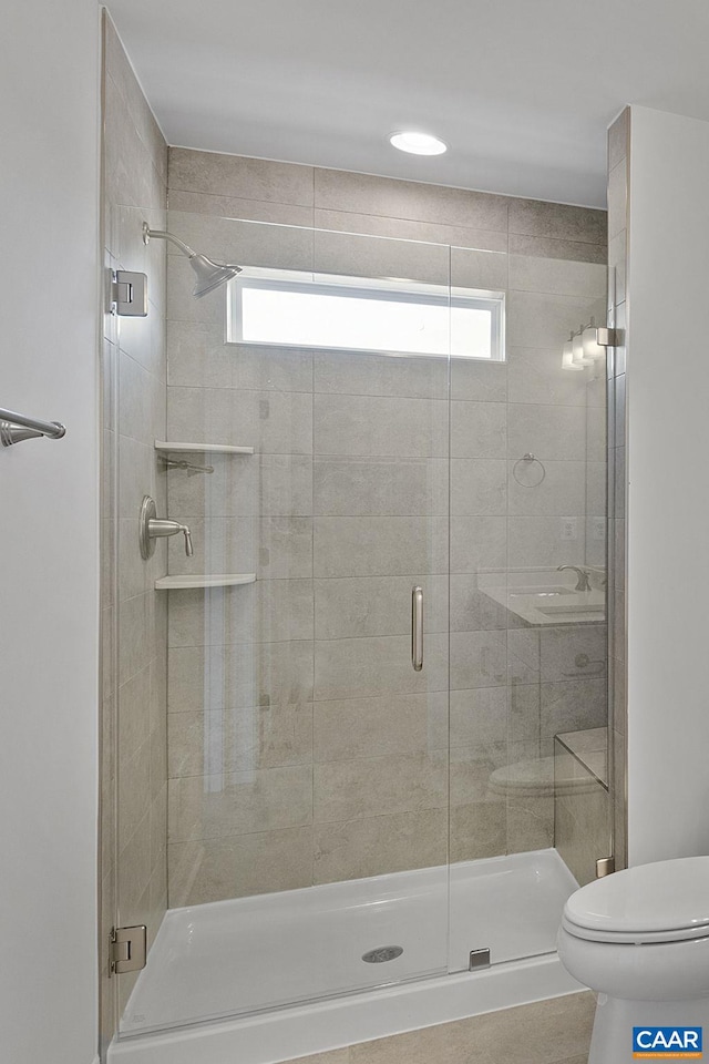 bathroom with a shower with door and toilet