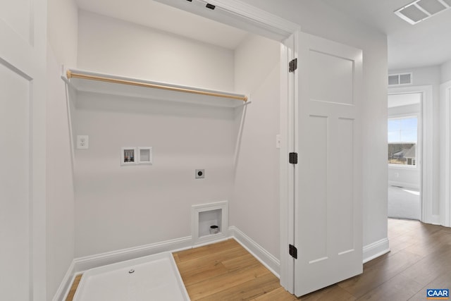 washroom featuring electric dryer hookup, hookup for a washing machine, and hardwood / wood-style flooring