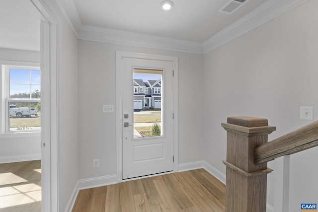 foyer entrance featuring ornamental molding and light hardwood / wood-style floors