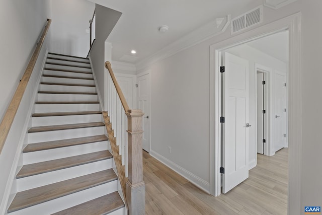 stairway featuring ornamental molding and hardwood / wood-style floors