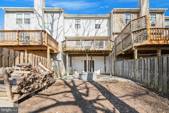 rear view of property featuring a wooden deck and a patio area