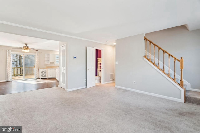 unfurnished living room with ornamental molding, carpet flooring, and ceiling fan