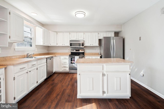 kitchen featuring stainless steel appliances, white cabinetry, sink, and dark hardwood / wood-style floors