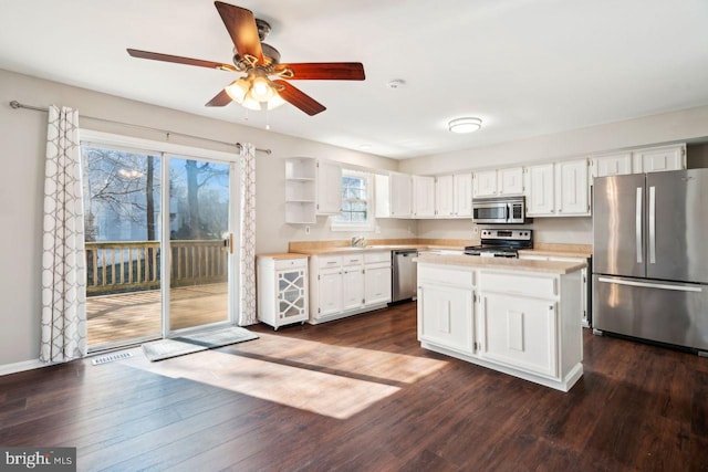 kitchen with stainless steel appliances, white cabinetry, sink, and dark hardwood / wood-style floors